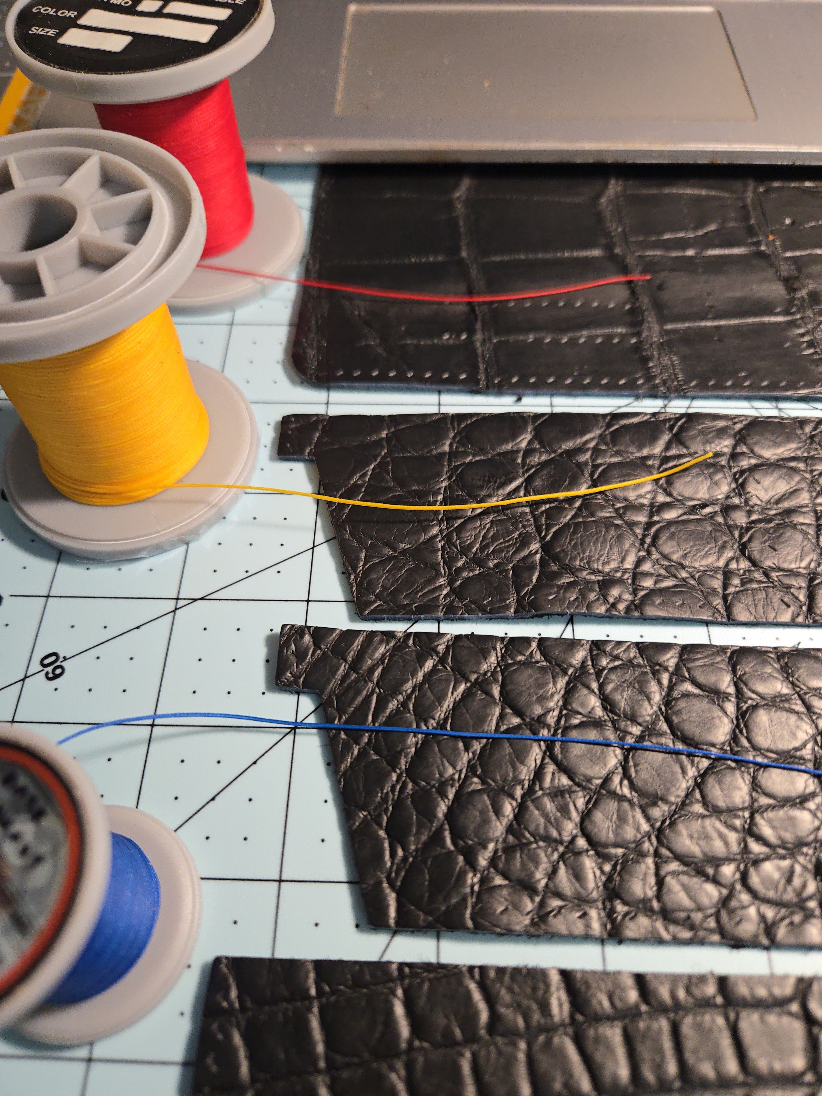 Thread selection — Black and Sapphire Blue Ritza spools against the leather panels