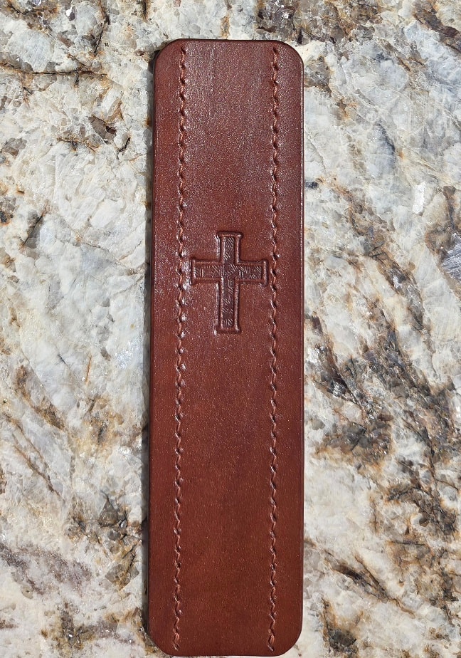 Bookmark front face — cross stamp detail, granite flat lay