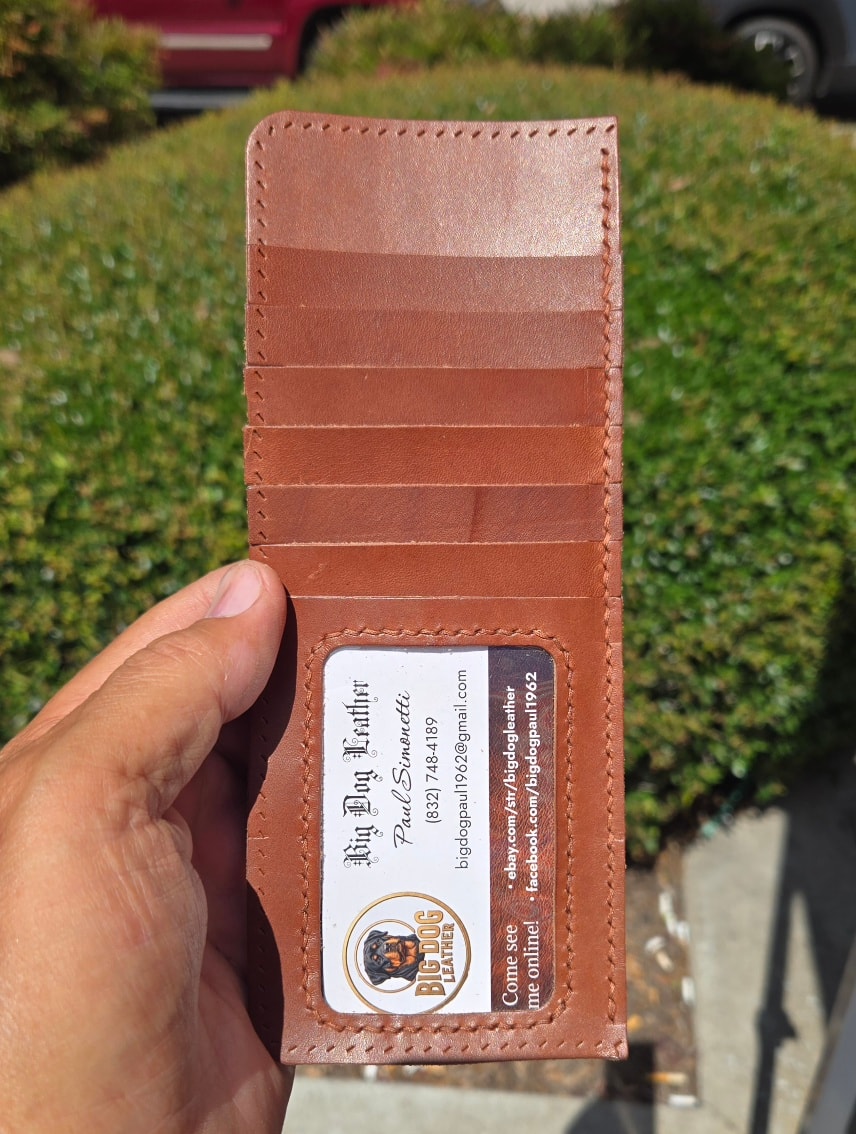 Hand holding long wallet open showing card slots