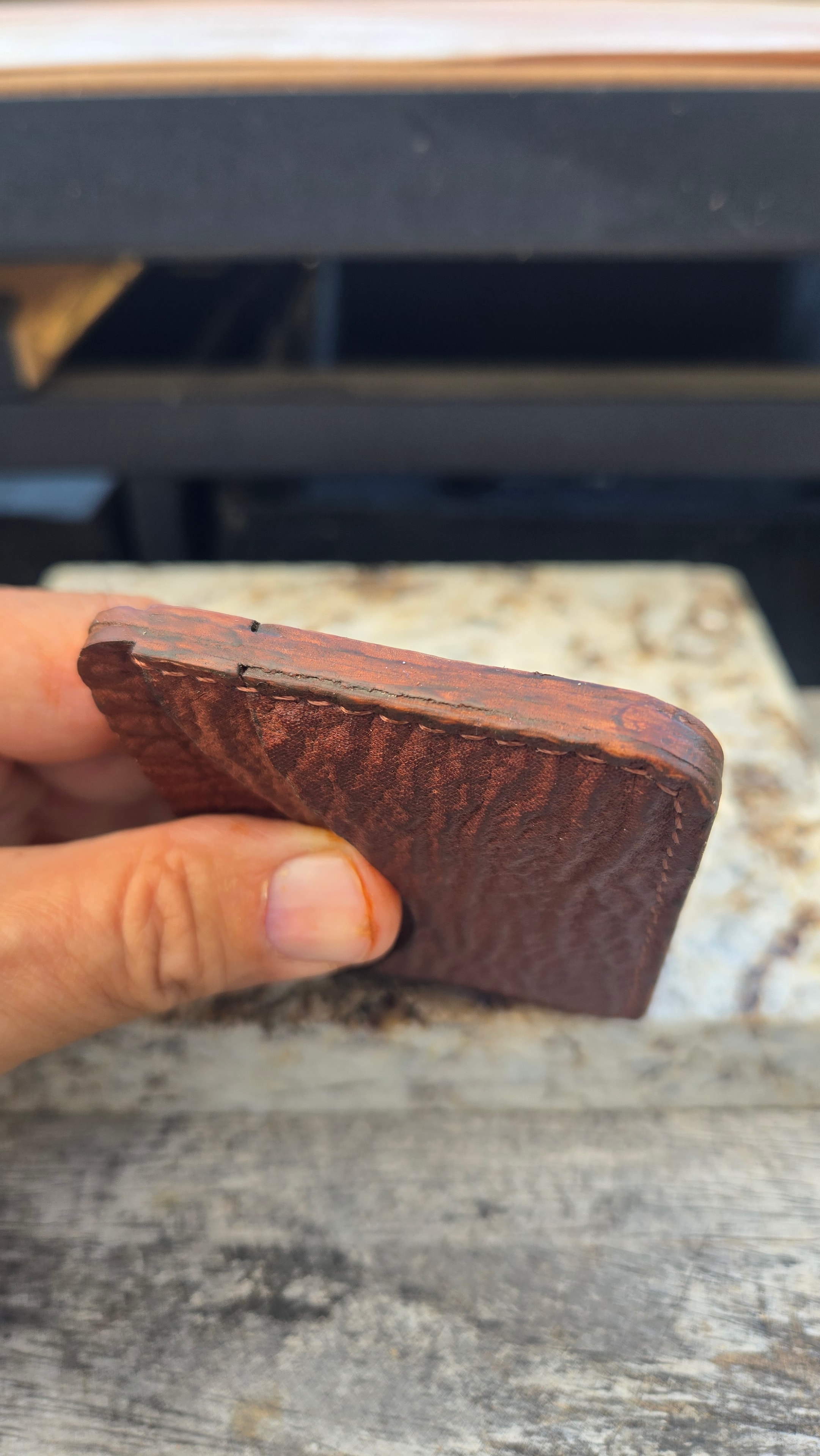 Wallet in hand — corner and edgework detail