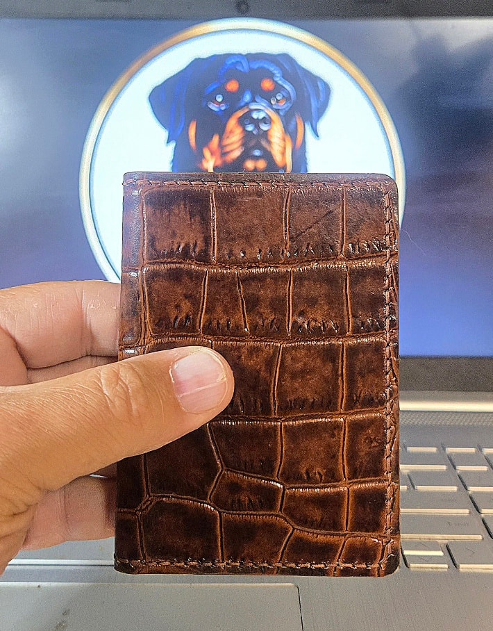 XL1 Mauri croc embossed bifold — exterior front, hand-held side view